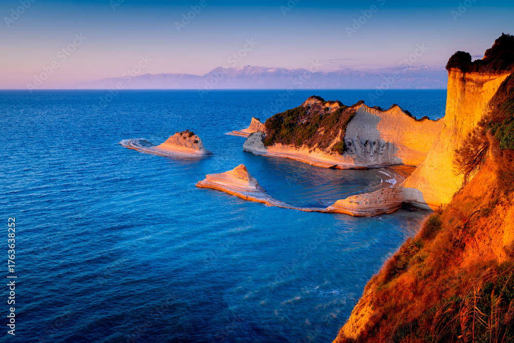 Ταπετσαρία Cape Drastis rock formations on island Corfu at sunset, Greek coastline landscapes with rocks