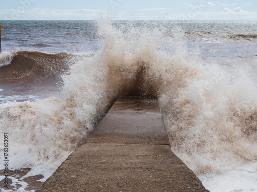 Large wave crashing onto breakwater in Devon