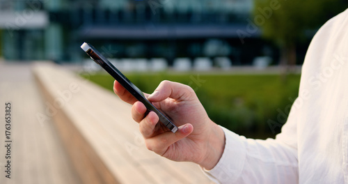Close up of males hands use mobile phone outdoors