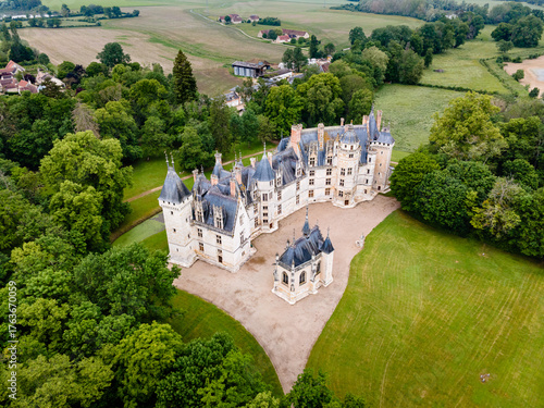 Aerial shot of Château de Meillant in Meillant, France, showing the château and its clear-standing chapel amid lush green fields and scattered trees.

