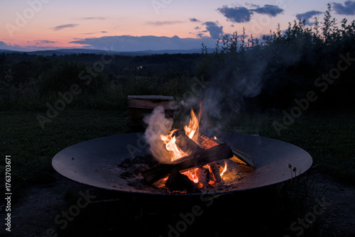 round circle fire pit burning logs at sunset in catskills mountains catskill upstate new york travel camping leisure scenic nature landscape flame wood wooden log warmth cozy outdoor adventure