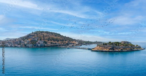 Wide panoramic view of Kusadasi town and pigeon island (güvercinada) castle under a bright blue sky, Turkey