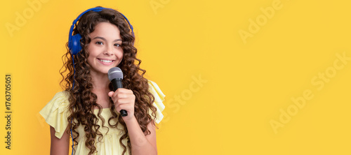 wireless audio accessory. Child portrait with headphones, horizontal poster. Girl listening to music, banner with copy space.