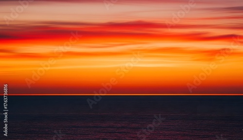 Fototapeta Naklejka Na Ścianę i Meble -  Dramatic sunset over the ocean vibrant colors fill the sky creating a serene and peaceful seascape