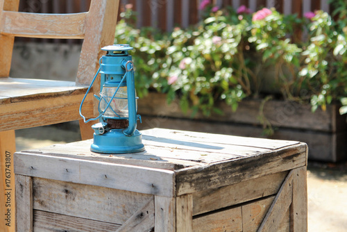A blue old vintage lamp on a old wooden crate