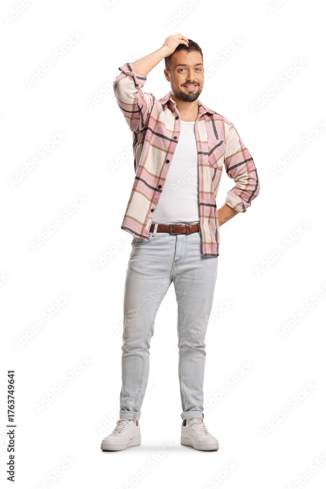 Fototapeta premium Full length portrait of a guy in checkered shirt holding his head and smiling