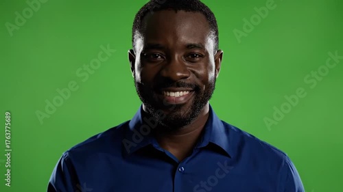 Professional Portrait of a Confident Smiling Businessman of African Descent Standing Against a Bright Green Screen in Formal Blue Shirt for Corporate, Marketing, or Business Presentation Use