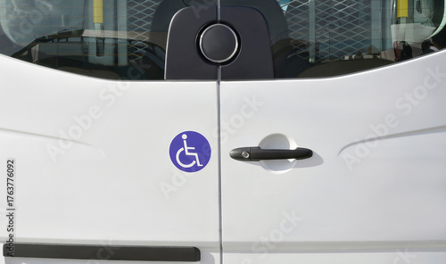 Fotografia Rear doors of a white vehicle for transporting people with reduced mobility with a symbol of a person in a wheelchair