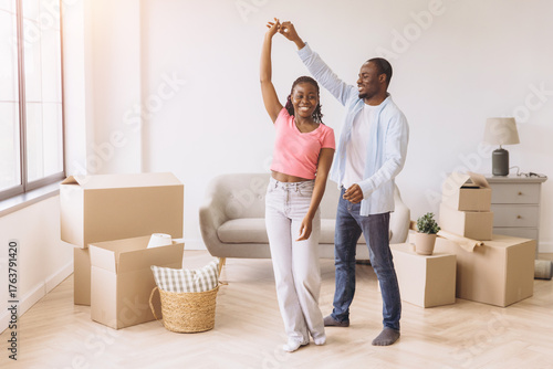 African couple dancing celebrating moving to new home