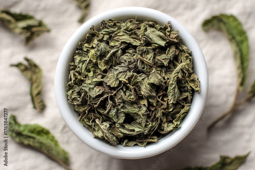 Fototapeta premium Dried herbs in a white bowl on a textured background showcasing culinary use and freshness