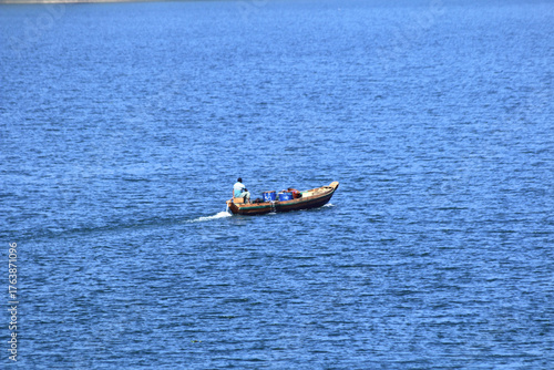 Fisherman on Wooden Boat in Calm River