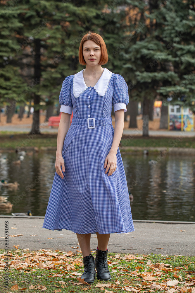 Fototapeta premium Portrait of a young woman in a blue dress with a white collar