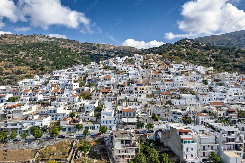 Naklejka premium Aerial panoramic view of Filoti village in Naxos, Greece, captured by drone, showcasing the traditional whitewashed houses, winding streets, and beautiful mountainous landscape.