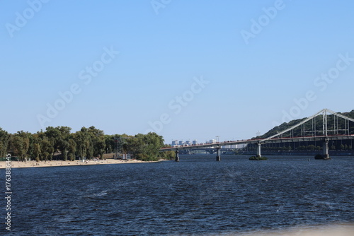 view on Dnipro river, Trukhaniv Island and Parkoviy bridge from quay, Kyiv, 2025