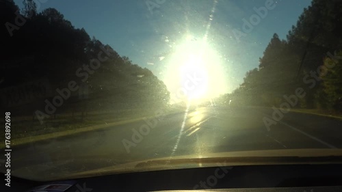 Solomons, Maryland USA A dashboard view of blinding light from the autumn sunrise on a highway. 