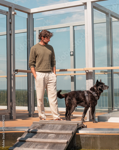 Man and dog at the top of a cruise while travelling in summer weather