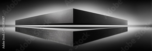 Black monolithic geometric structure with glowing white reflection and contrast.