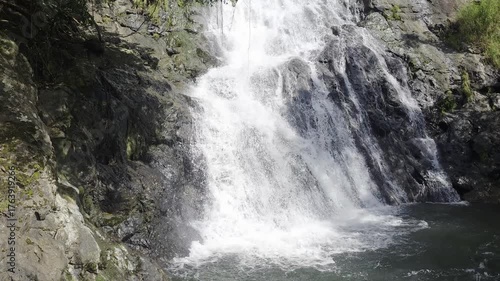 Serene Waterfall Cascading Into Clear Pool Surrounded by Lush Greenery and Rocks