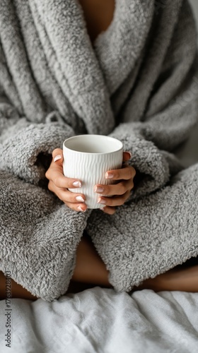 Cozy Morning Scene With a Person Holding a Warm Cup in a Soft Robe Indoors