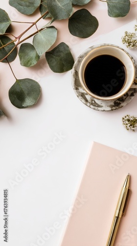 Coffee and Leaves on a Clean Desk With a Notebook and Pen in Soft Morning Light