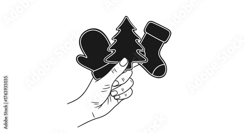 Hand holding festive christmas cookie cutters: mittens, tree, stocking