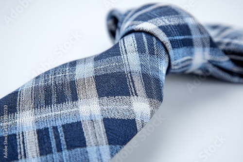 Stylish Blue Plaid Tie Neatly Arranged on a Soft White Background for Elegant...