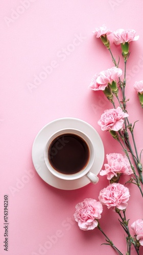 Delicate Pink Flowers and a Cup of Dark Coffee on a Soft Pink Surface in a Co...