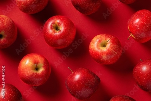 Fresh Red Apples Scattered on a Vibrant Red Surface Create a Striking Visual ...