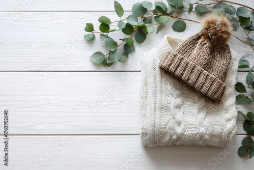 Cozy Knit Hat and Sweater With Greenery on a Wooden Surface in a Warm Setting