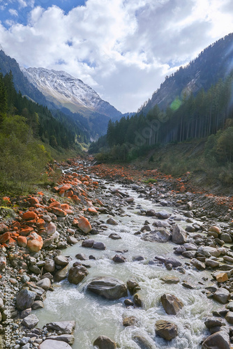 Schönes Panorama im Obersulzbachtal in den österreichischen Alpen, Mit rot-orange farbigen Flechten bewachsene Felsen.