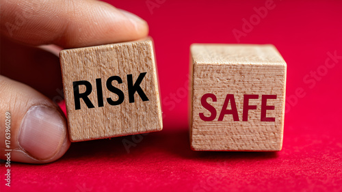 Risk and safe blocks held by fingers representing decision thresholds risk assessment and the trade off between protection and opportunity
