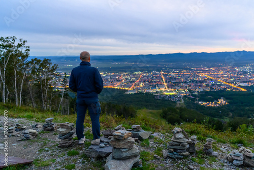 Experiencing the serene beauty of the evening cityscape from a peaceful mountain viewpoint