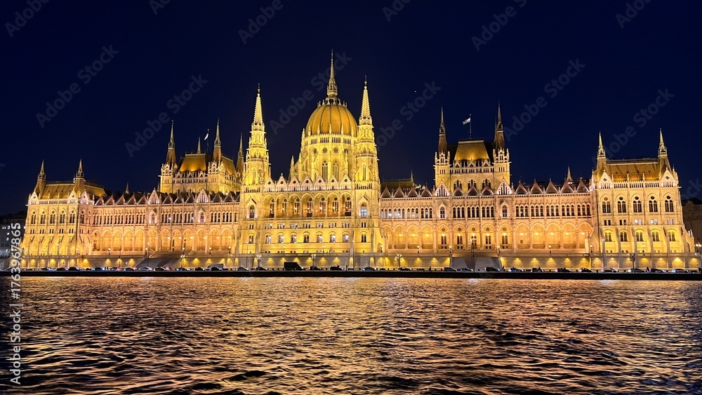 Naklejka premium Hungarian parliament building illuminating danube river at night