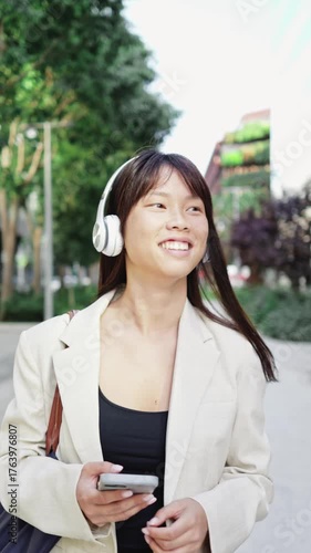 Businesswoman listening music and walking in slow motion