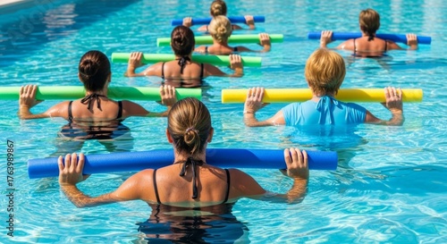 Group of women exercising in pool with noodles for aqua aerobics class