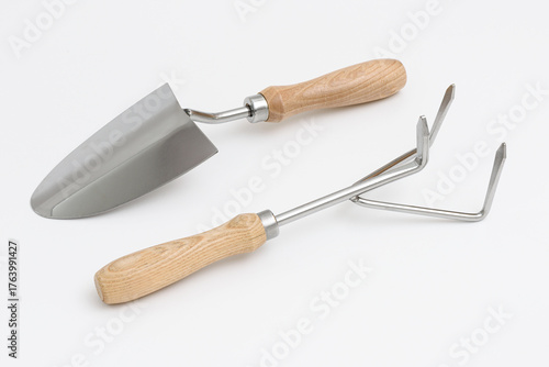 Small garden trowel. A metal trowel with a wooden handle, ideal for digging, planting, and removing weeds, characterized by its sturdy construction and ergonomic design for efficient gardening tasks.