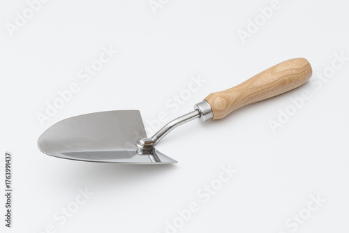 Small garden trowel. A metal trowel with a wooden handle, ideal for digging, planting, and removing weeds, characterized by its sturdy construction and ergonomic design for efficient gardening tasks.