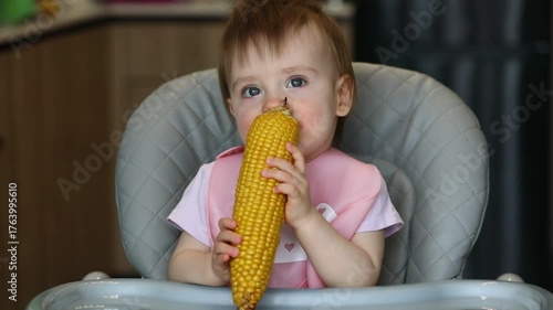 A little girl eats an ear of corn with gusto.