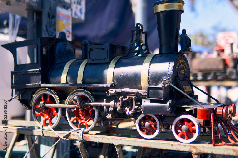 Fototapeta premium View of a colorful, well-maintained, handcrafted locomotive. For decoration or souvenirs. Made from recyclable materials. In a public place, with natural light.