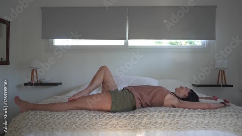 Happy woman smiling and relaxing on her bed