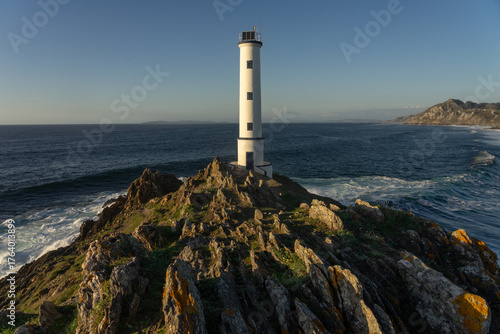 Cabo (cape) Home lighthouse on the cliffs at sunset in Rias Baixas zone in Galicia coast.