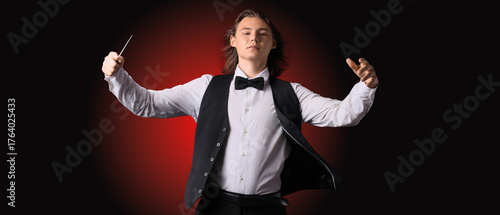 Male conductor on dark red ...