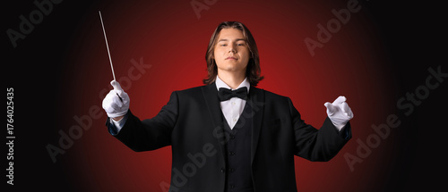 Male conductor on dark red ...