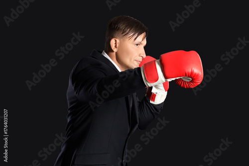 Male boxer in suit on dark ...