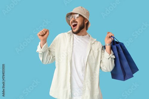 Happy young man with shoppi...