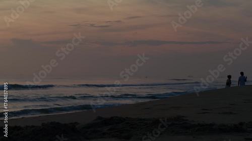 早朝の海で戯れる人々