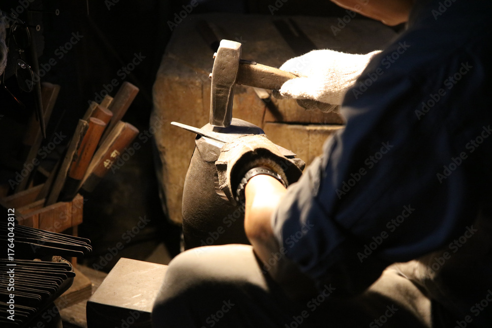 Obraz premium 丁寧に包丁のひずみ取りをする職人