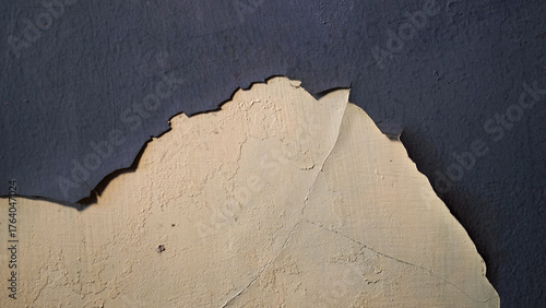 Wall with peeling and damaged black paint surface