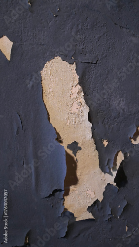 Wall with peeling and damaged black paint surface