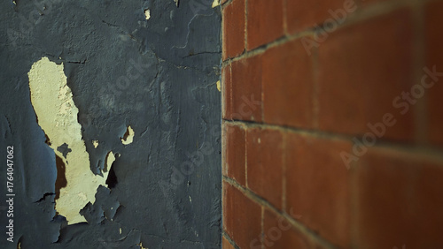 Walls with peeling and damaged black paint surfaces. Half a red brick wall